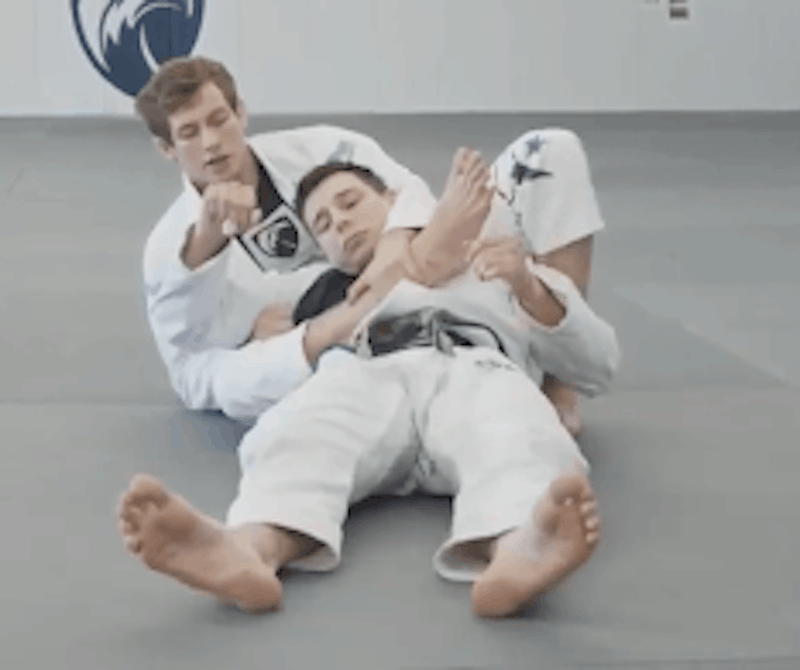 scoot-your-hips-back-into-a-triangle-position-to-further-isolate-your-opponent's-arm-for-the-armbar-from-the-back