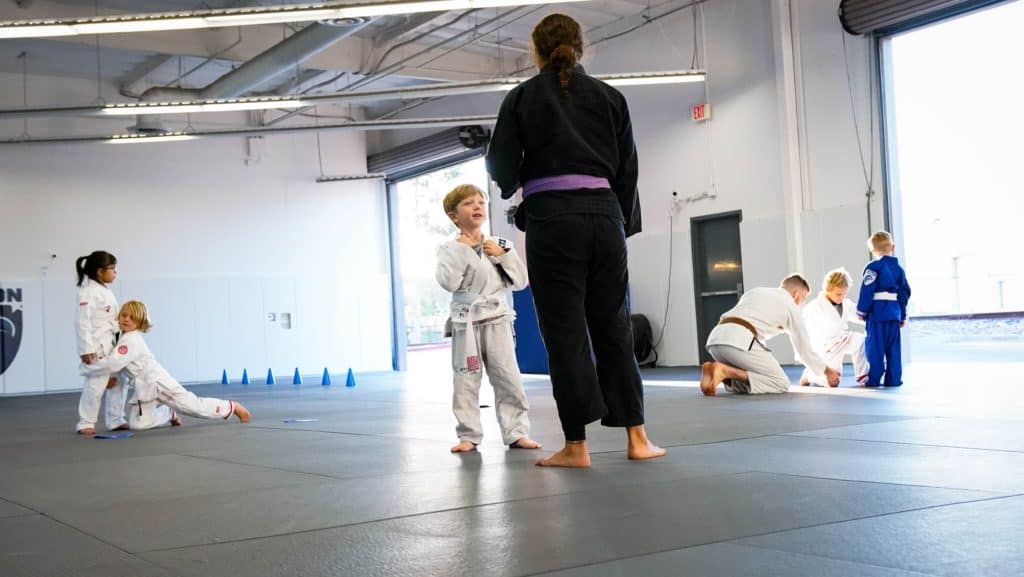 student-asking-question-during-kids-jiu-jitsu-class